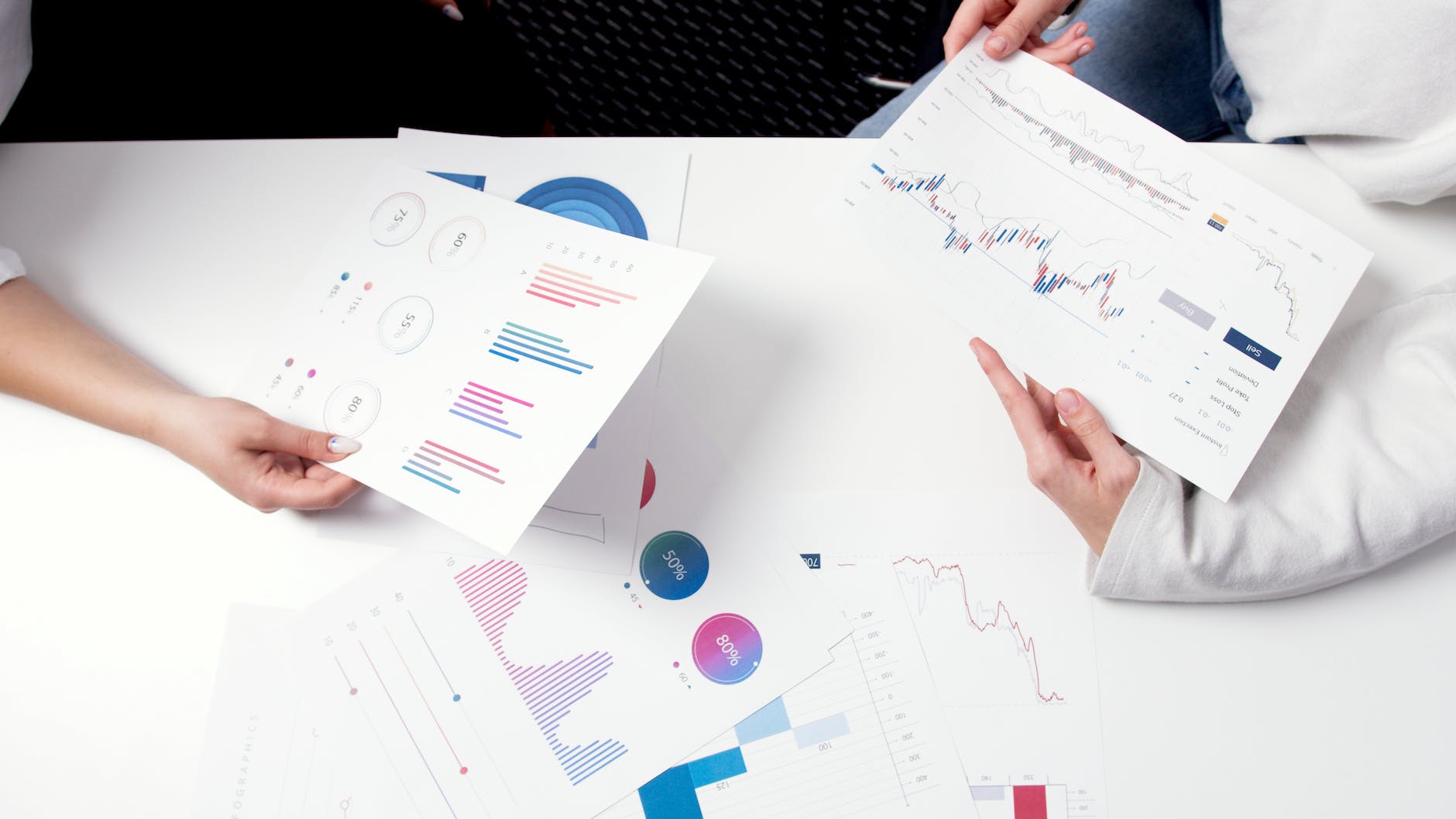 persons holding printer papers with graphs